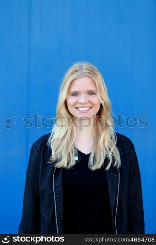 Cool blonde girl outdoor with a blue background