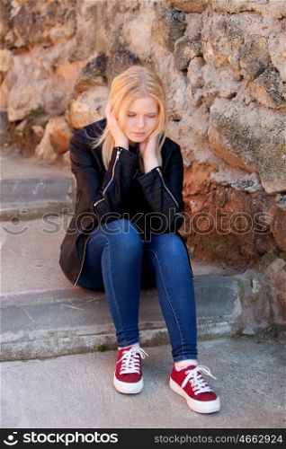 Cool blonde girl sitting outdoor looking down