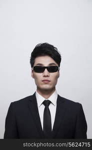 Cool businessman with sunglasses, studio shot