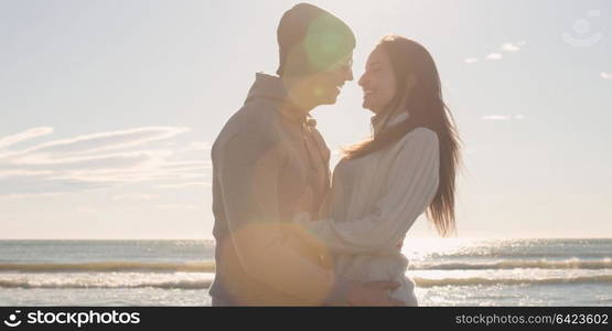 Cool Couple Laughing and hugging In Front Of Beach at beautiful autumn day