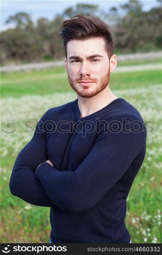 Cool handsome guy with beard at outside looking at camera