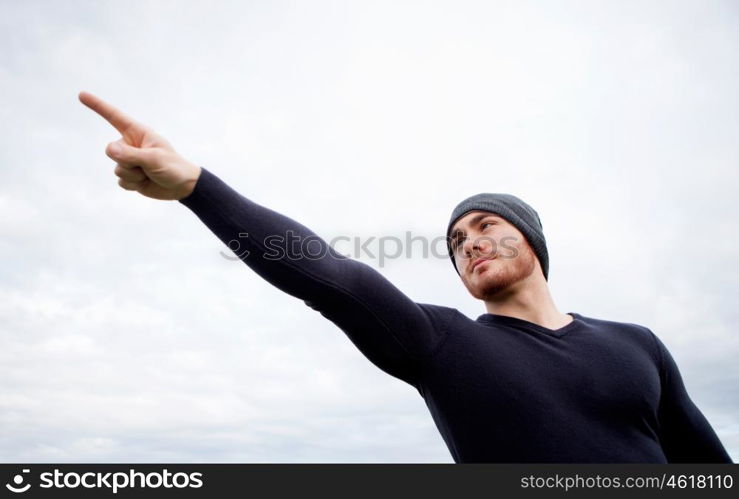 Cool handsome guy with beard at outside pointing something