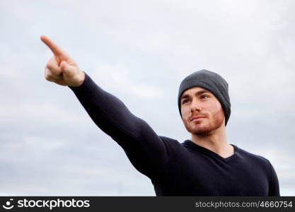 Cool handsome guy with beard at outside pointing something