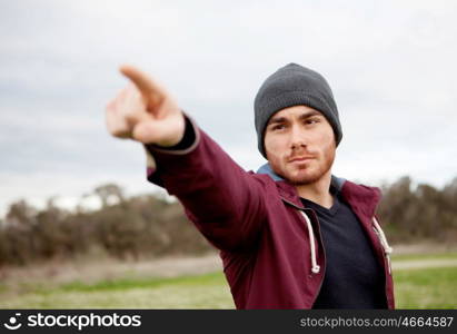 Cool handsome guy with beard at outside pointing something