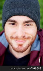 Cool handsome guy with piercing and beard smiling