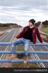 Cool handsome man at the top of a bridge over a highway&#xA;