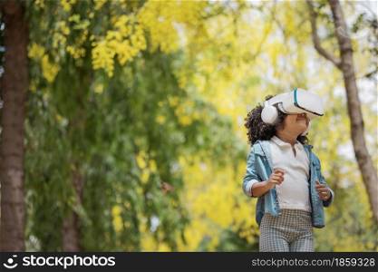 Cool millennial child exploring space with virtual reality glasses at outdoor