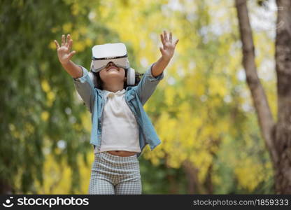 Cool millennial child exploring space with virtual reality glasses at outdoor