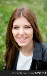 Cool pretty woman relaxed at the park with a leather jacket