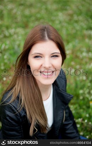Cool pretty woman relaxed at the park with a leather jacket
