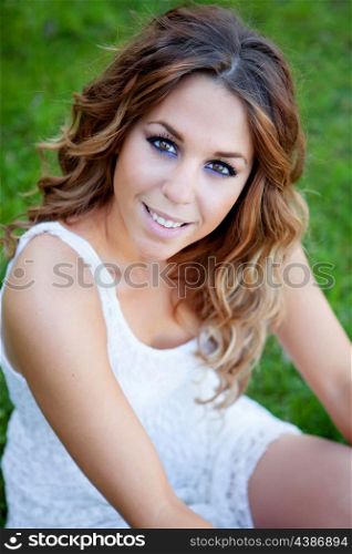 Cool pretty woman sitting on the grass with a beautiful smile