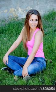 Cool pretty woman with pink t-shirt sitting on the grass