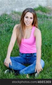 Cool pretty woman with pink t-shirt sitting on the grass