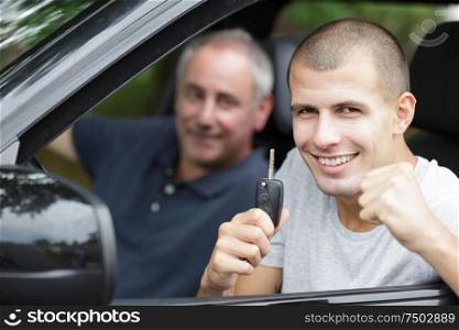 cool smiling happy man showing key car