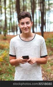 Cool teenager with sixteen years old and a mobile . Cool teenager with sixteen years old and a mobile in a forest