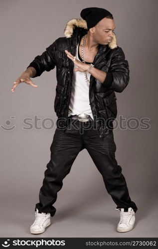 Cool young african american man dancing on grey background