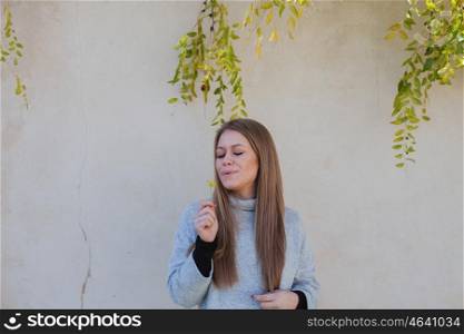Cool young girl smelling a yellow flower in a sunny day