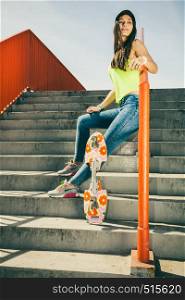 Cool young long haired girl with skateboard sitting on the urban railing. Active lifestyle funky in summer. Trendy sport teen.. Girl on stairs with skateboard.
