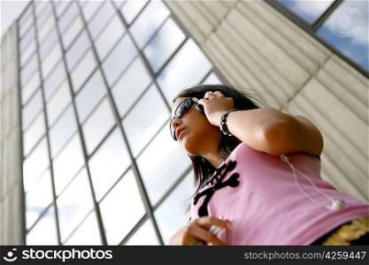 Cool young woman listening to music in the city