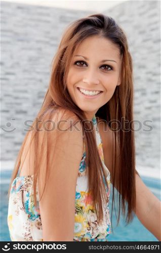 Cool young woman sitting on the edge of the pool
