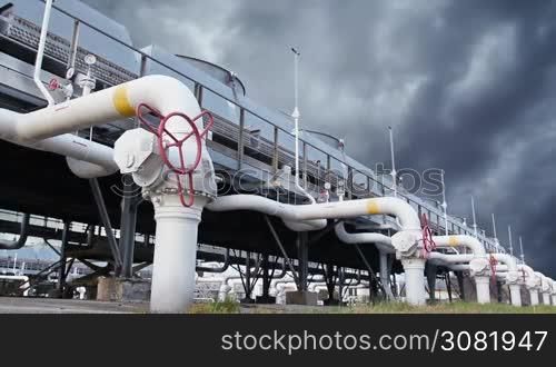 cooling installations at gas compressor station against background of thunderstorm sky, timelapse
