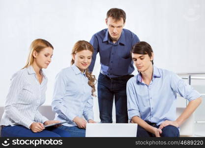 Cooperate for productive work. Four co-workers discussing business ideas in office