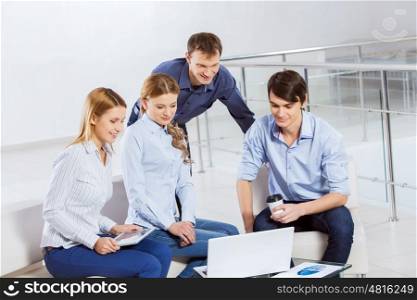 Cooperate for productive work. Four co-workers discussing business ideas in office