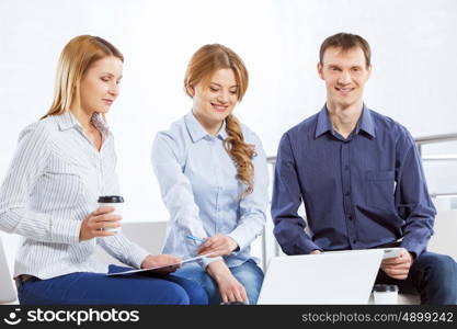 Cooperate for productive work. Three co-workers discussing business ideas in office