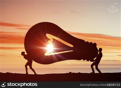 Cooperate for successful work. Business people carrying light bulb representing collaboration concept