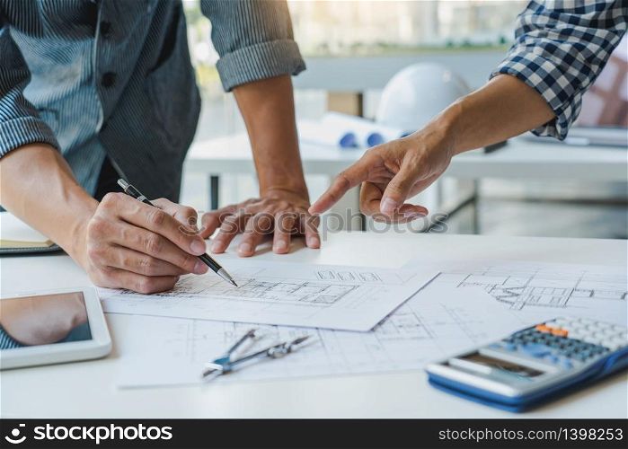 Cooperation Corporate designers in the office are working on a new project Planning blueprint Design at construction site at desk in office