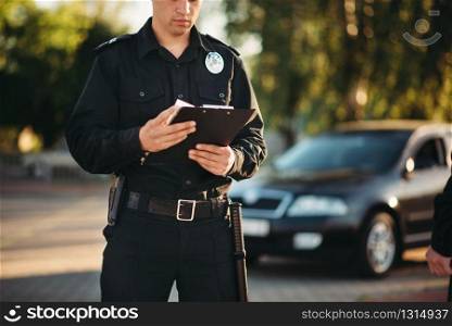 Cop in uniform with notebook in hands check the car on road. Law protection, car traffic inspector, safety control job. Cop with notebook in hands check the car