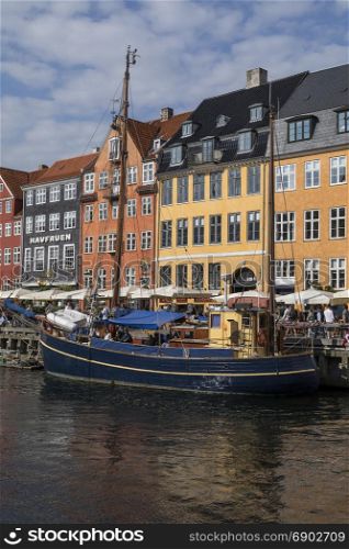 Copenhagen - Denmark. Nyhavn or New Harbour is a 17th century waterfront, canal and entertainment district from Kongens Nytorv to the harbour front. It is lined by brightly coloured 17th and early 18th century townhouses, bars, cafes and restaurants. It is very popular with tourists.
