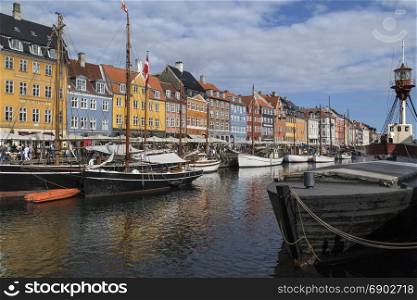 Copenhagen - Denmark. Nyhavn or New Harbour is a 17th century waterfront, canal and entertainment district from Kongens Nytorv to the harbour front. It is lined by brightly coloured 17th and early 18th century townhouses, bars, cafes and restaurants. It is very popular with tourists.