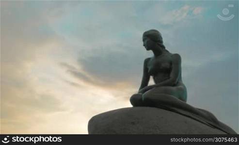 COPENHAGEN, DENMARK - SEPTEMBER 10, 2015: Low angle shot of Little Mermaid statue on the background of evening sky. City icon which has been major tourist attraction since 1913