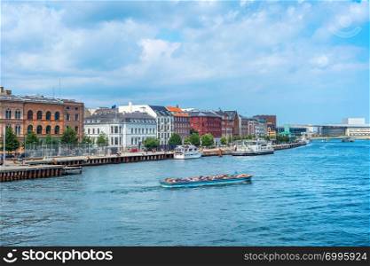 Copenhagen harbor view, boat with tourists and modern city skyline in sunshine weather with cloudy sky, Denmark