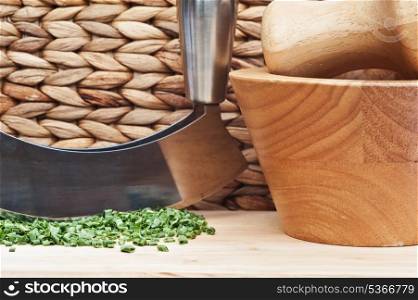 Copped chives in rustic kitchen setting with herb chopper and pestle and mortar