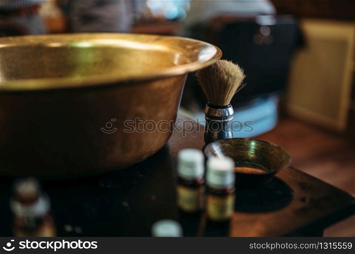 Copper bowl and shaving equipment on the table at barber shop. Hairdressing salon interior on background . Bowl and shaving equipment