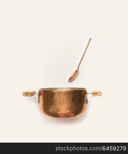 Copper cooking pot with spoon on white background.