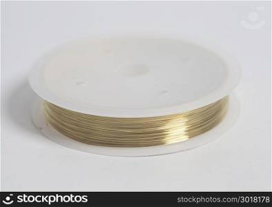 Copper wire on spool on white background