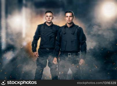 Cops in black uniform and body armor. Two police officers in special ammunition. Cops in black uniform and body armor