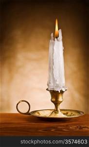 copy space image of ablaze candle in old candlestick