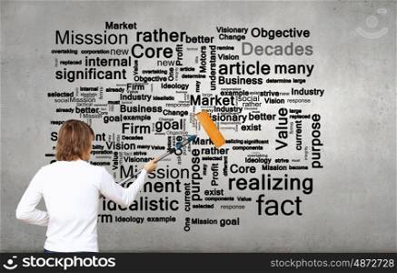 Copyright concept. Young businessman standing with back and painting different words on wall