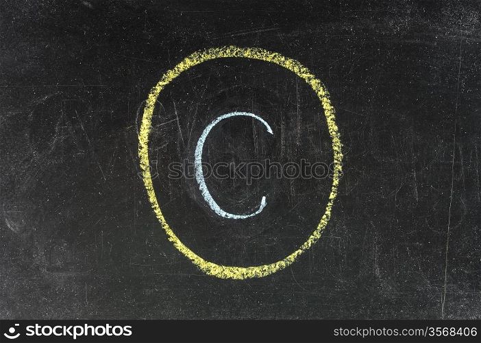 copyright symbol sketched with white chalk on blackboard