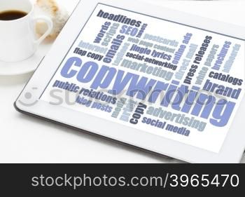 copywriting word cloud in blue and white on a digital tablet with a cup of coffee