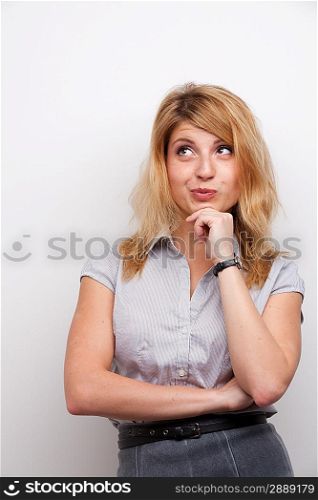 coquettish woman with the hand on her chin studio shot grey background
