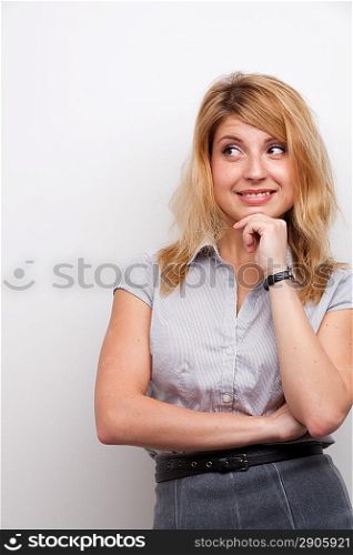 coquettish woman with the hand on her chin studio shot grey background