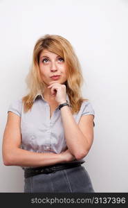 coquettish woman with the hand on her chin studio shot grey background