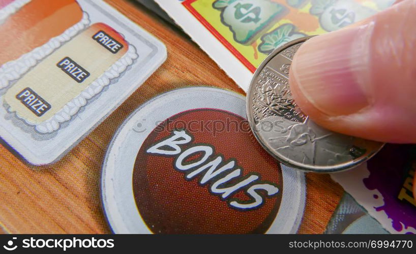 Coquitlam, BC, Canada - October 05, 2018 : Close up of woman scratching lottery ticket. The BC Lottery Corporation has provided government sanctioned lottery games in BC since 1985.. Close up of woman scratching lottery ticket.