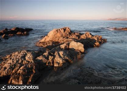 Coriscan rocks in sea at dusk. Red rocks off the coast of northern Corsica looking towards Cap Corse