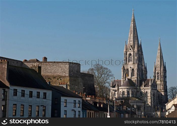 Cork cityscape featuring at the left Elizabeth Fort and on the right Saint Fin Barre&rsquo;s Cathedral, Ireland (blue sky background)